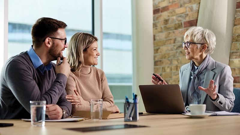 Image of several business people having a discussion in an office setting